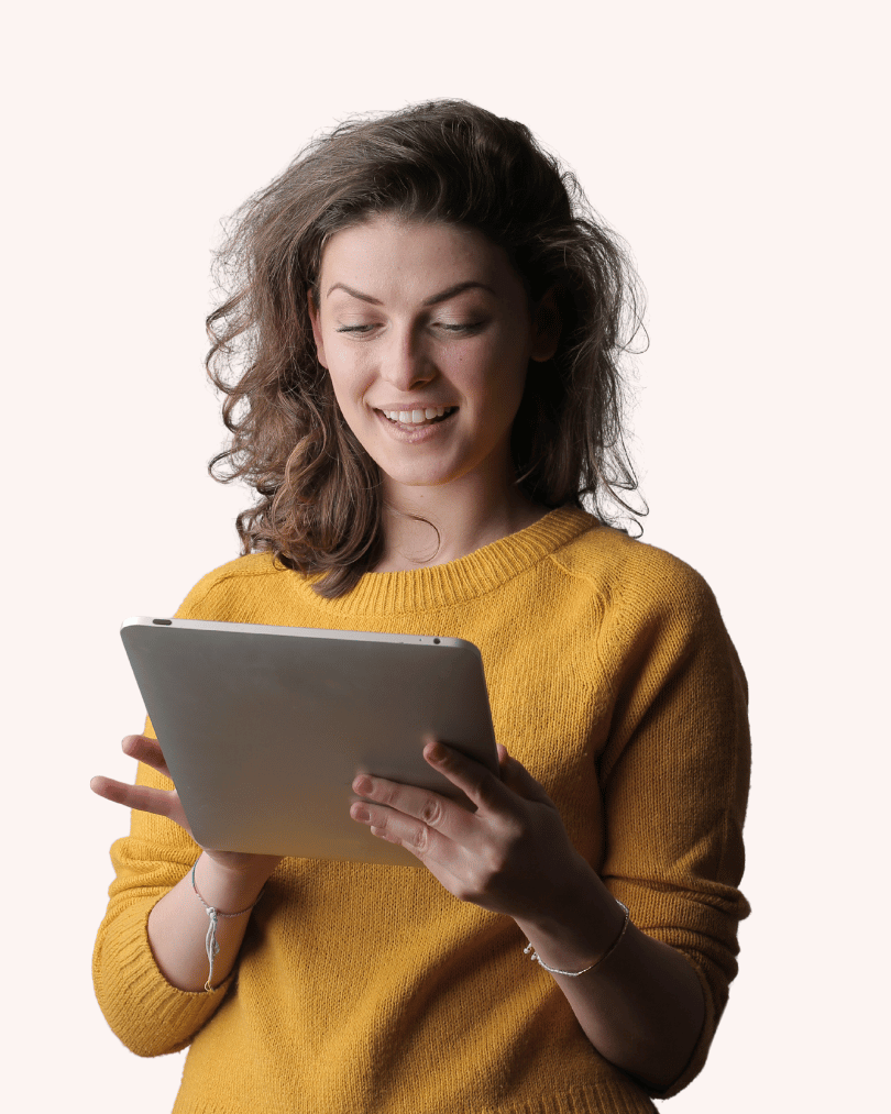 Chica mirando a la tablet fondo rosa claro